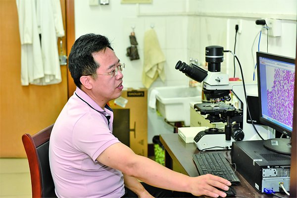 图为新冠肺炎疫情防控期间,动科学院成子强教授边操作显微镜,边给学生讲授《动物病理学》实验课内容。